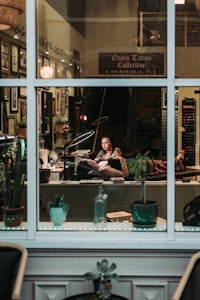 a man sitting at a table in front of a window
